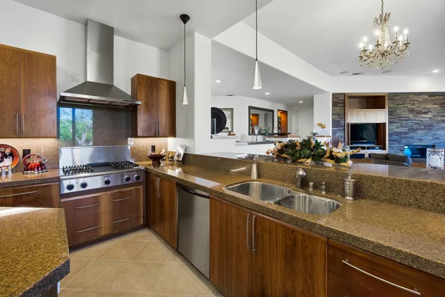 a kitchen with stainless steel appliances granite countertop a sink a stove and a refrigerator