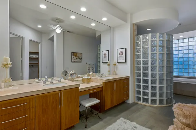 a spacious bathroom with a double vanity sink a mirror and a bathtub