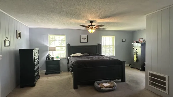 a bedroom with a bed and a tv on the dresser