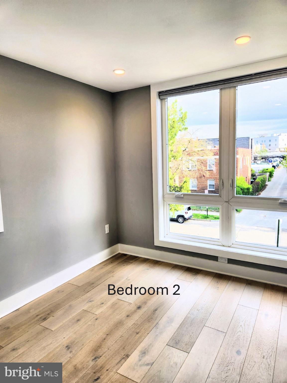 1915 H Street Northeast Washington, DC 20002 - Photo 11 of 14 an empty room with wooden floor and windows