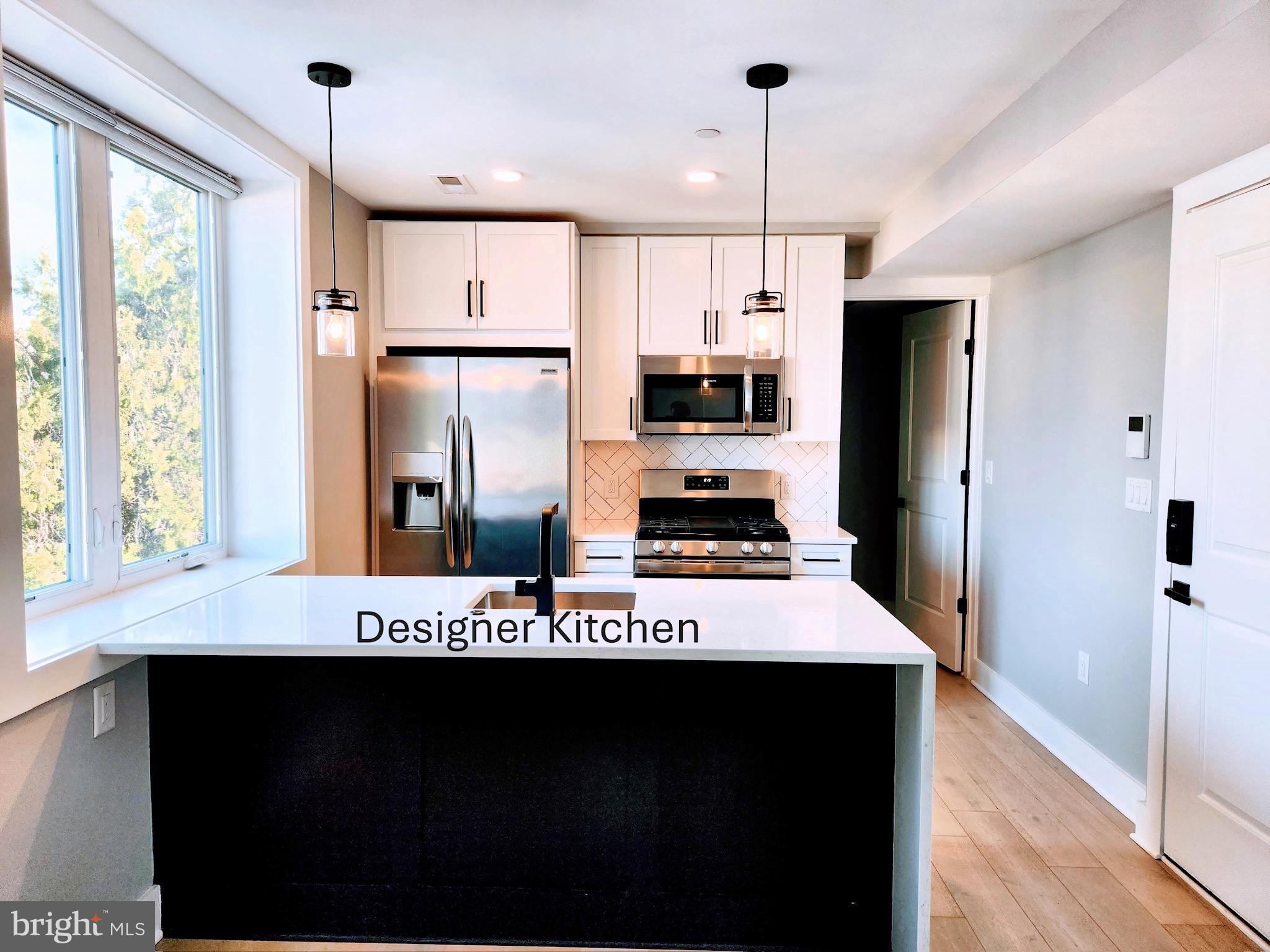 1915 H Street Northeast Washington, DC 20002 - Photo 2 of 14 a kitchen with stainless steel appliances kitchen island granite countertop a refrigerator a stove and a sink with wooden floor