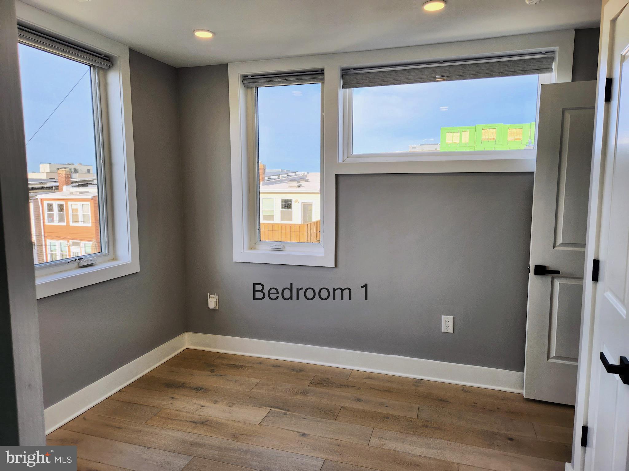 1915 H Street Northeast Washington, DC 20002 - Photo 5 of 14 a view of an empty room with a window and wooden floor
