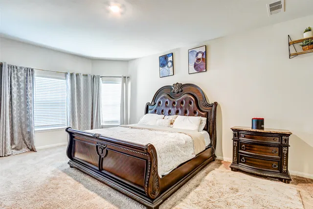 a bedroom with a bed and a large window