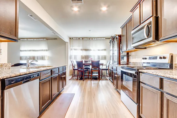a kitchen with stainless steel appliances granite countertop sink stove top oven and cabinets