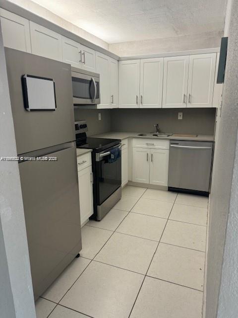 17530 Northwest 68th Avenue, Unit C2004 Hialeah, FL 33015 - Photo 1 of 6 a kitchen with a sink a stove top oven and white cabinets