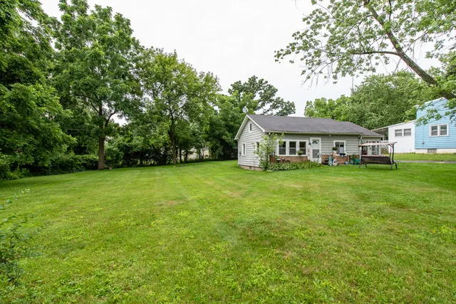 a view of house with garden space and trees in the background