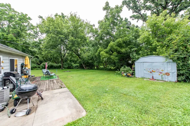 a patio with a table and chairs and potted plants