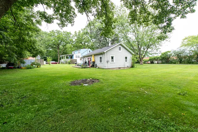 a view of a house with a big yard and large trees