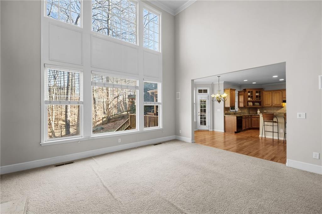 403 Glenhurst Trace Canton, GA 30115 - Photo 19 of 73 an empty room with large windows and kitchen view