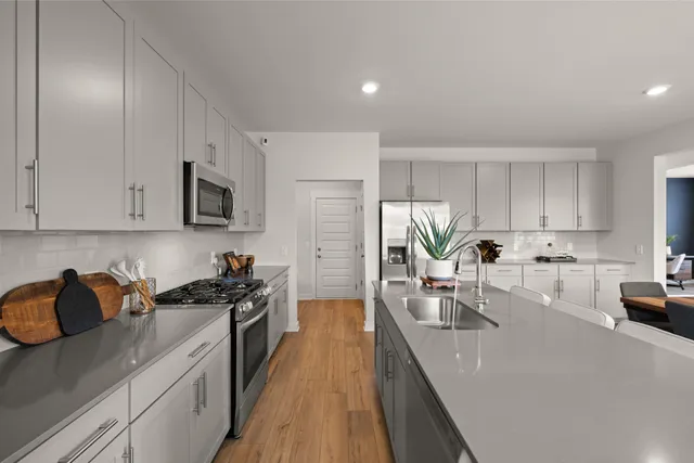 a kitchen with kitchen island white cabinets and appliances