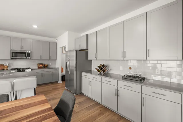 a kitchen with white cabinets and appliances