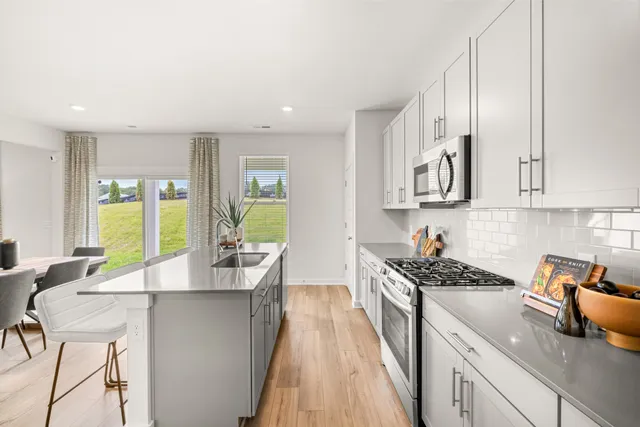 a kitchen with granite countertop a sink a counter space appliances and cabinets
