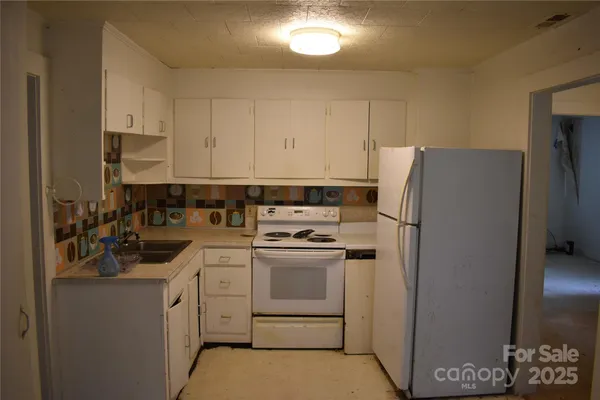 a kitchen with a refrigerator sink and cabinets