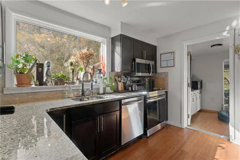 a kitchen with stainless steel appliances granite countertop a sink stove and refrigerator
