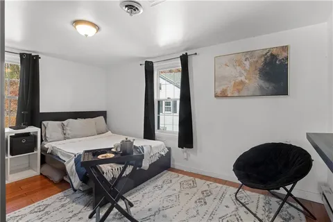 a bedroom with a bed and wooden floor