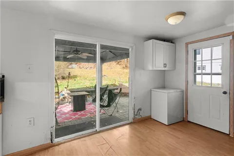 a view of a room with a large window and wooden floor