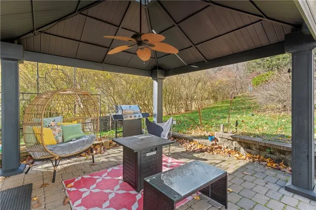 a outdoor space with the couches and dining table under an umbrella