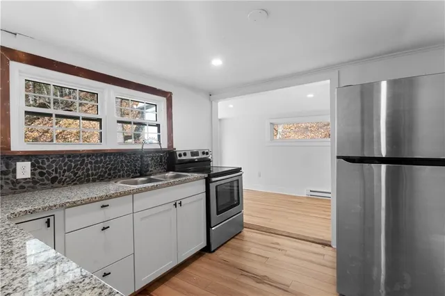 a kitchen with stainless steel appliances granite countertop a refrigerator and a sink