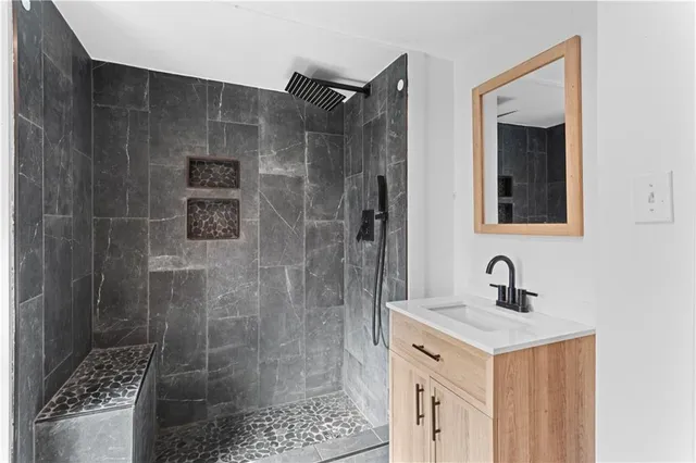 a bathroom with a shower sink and mirror