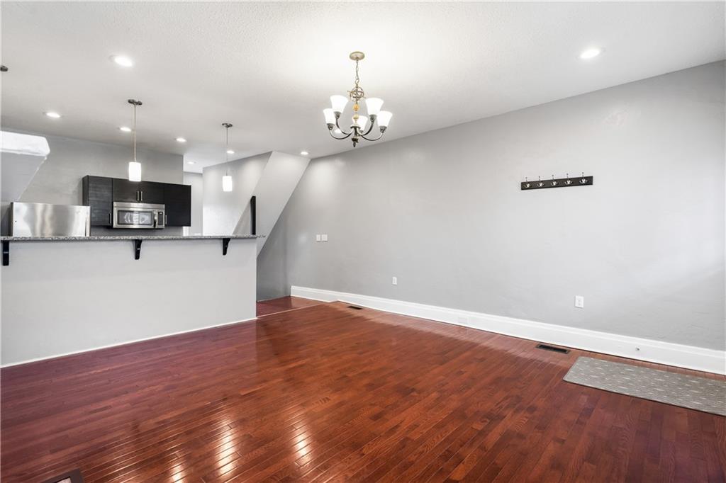 2918 Spring Street Pittsburgh, PA 15210 - Photo 5 of 25 wooden floor in an empty room with a kitchen