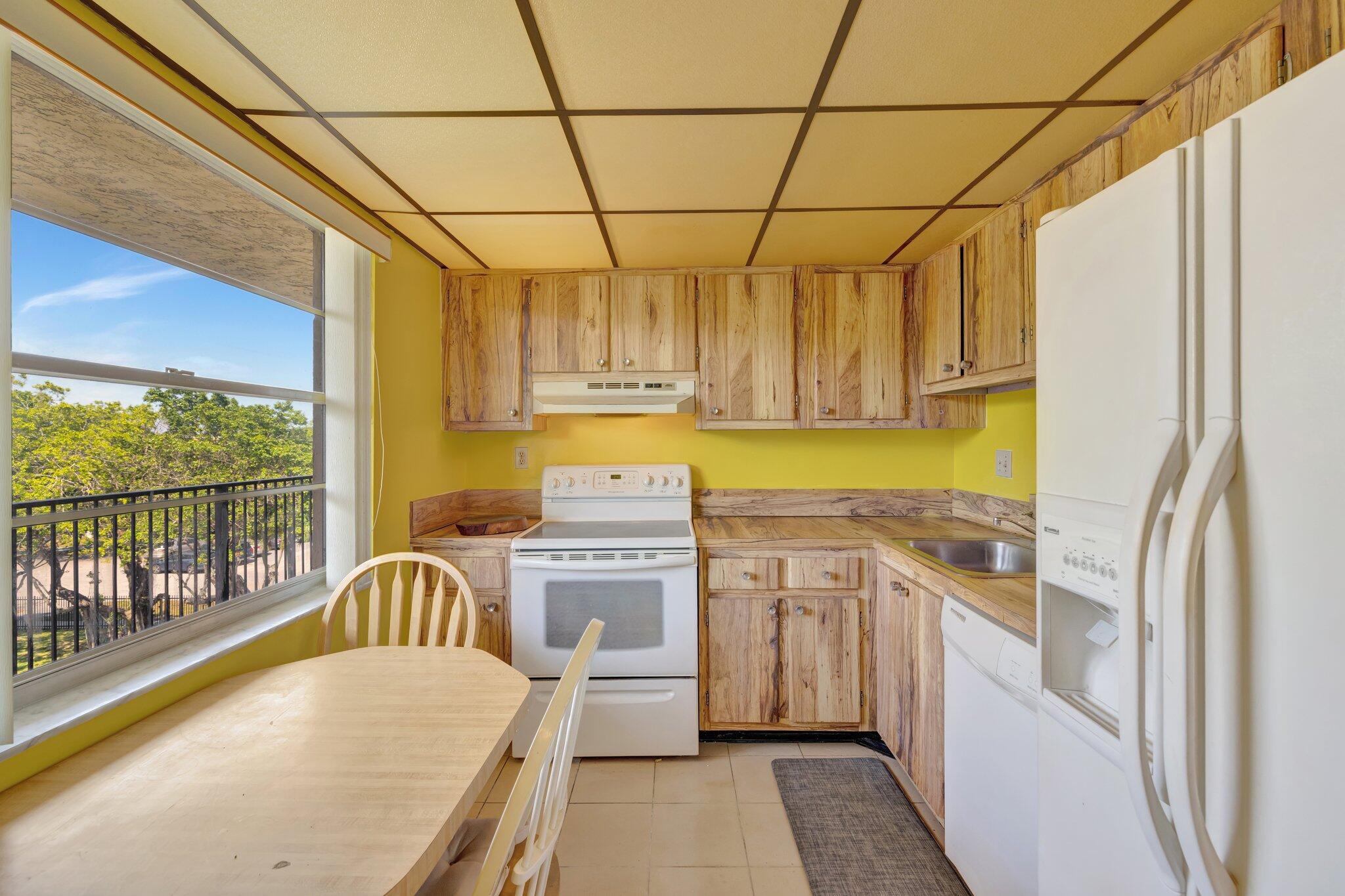 3301 Northwest 47th Terrace, Unit 410 Lauderdale Lakes, FL 33319 - Photo 3 of 58 a kitchen with stainless steel appliances granite countertop a sink a stove cabinets counter space and a window