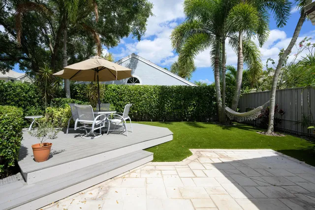 a view of a patio with a table and chairs under an umbrella