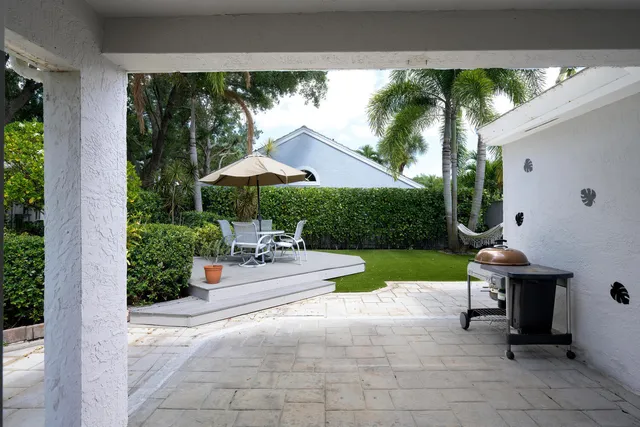 a view of a patio with a table and chairs under an umbrella