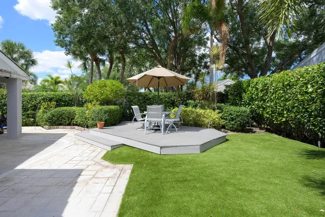 a view of a swimming pool with a patio and a yard
