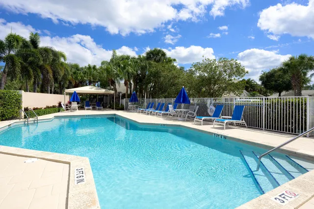 a view of a swimming pool with a patio and a yard