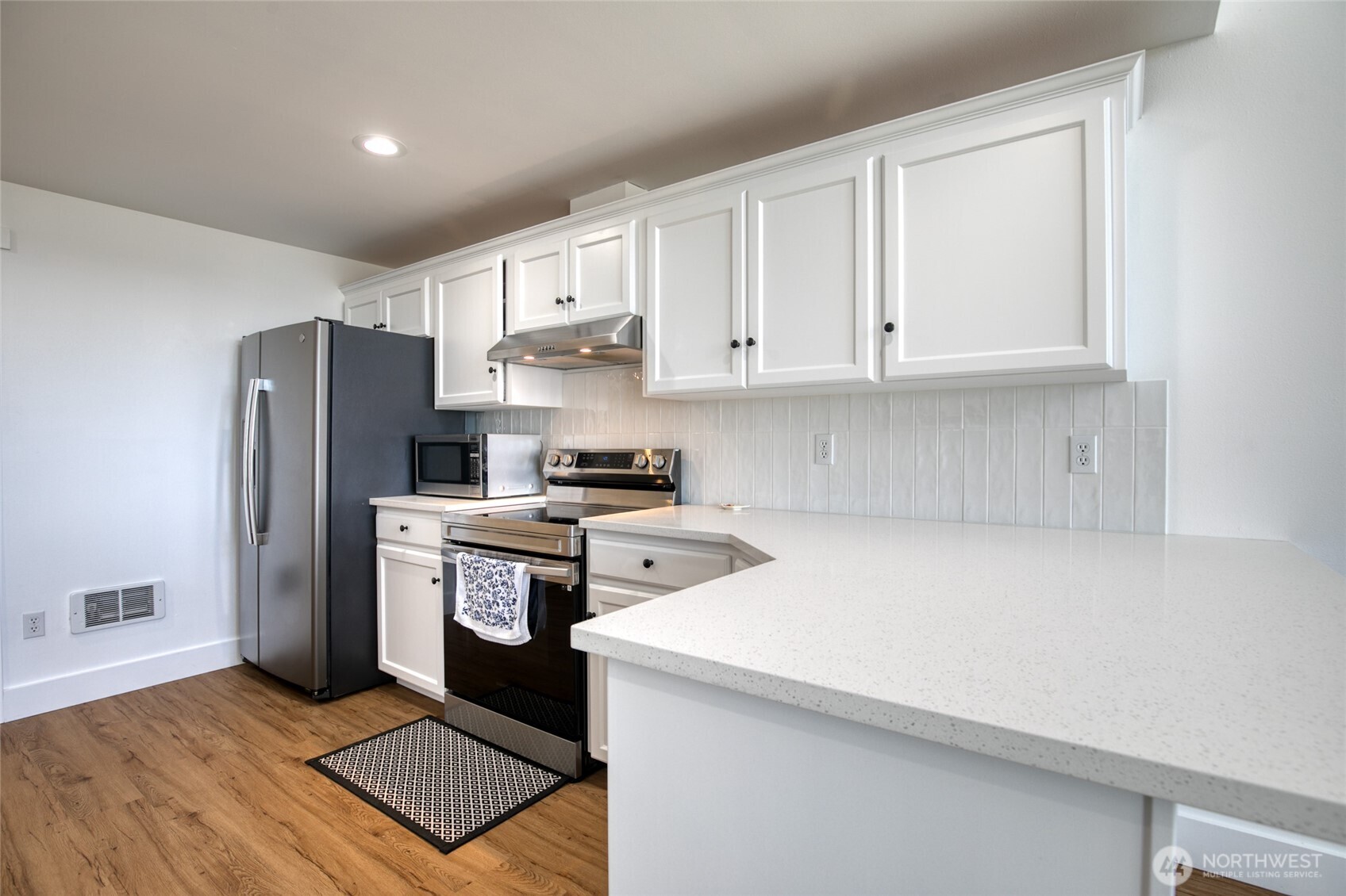 1472 Storm King Way Southwest, Unit A Ocean Shores, WA 98569 - Photo 17 of 39 a kitchen with a refrigerator sink and cabinets