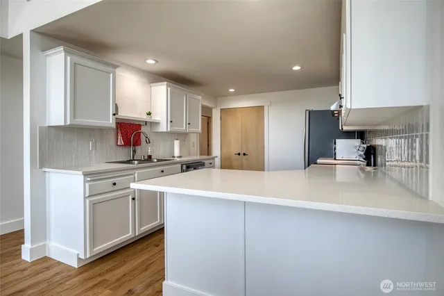 a kitchen with white cabinets and sink