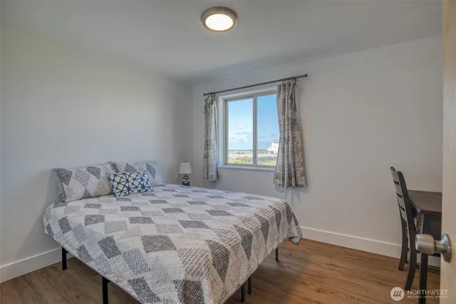 a bedroom with a bed and a dresser next to a window