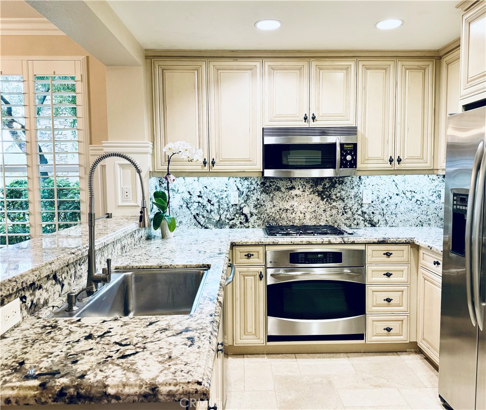 a kitchen with stainless steel appliances a stove a sink a microwave and cabinets