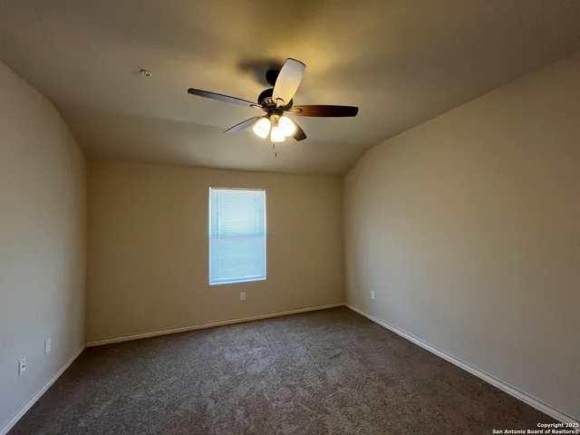 a view of a room with a ceiling fan and a window