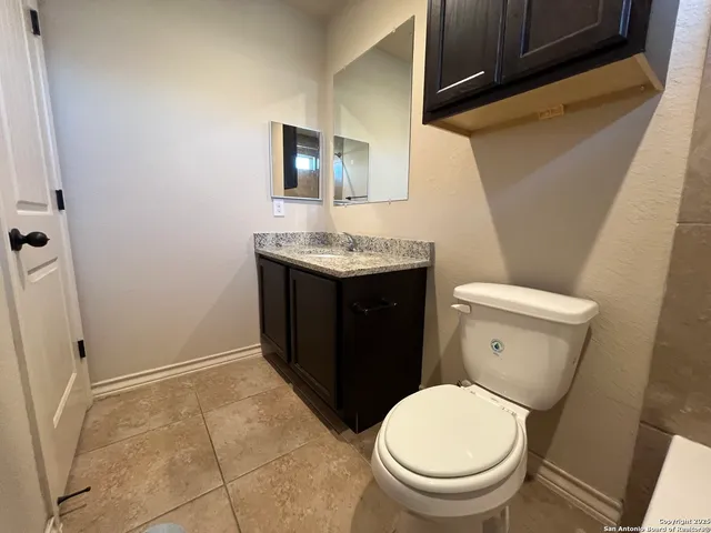 a bathroom with a toilet a sink and mirror
