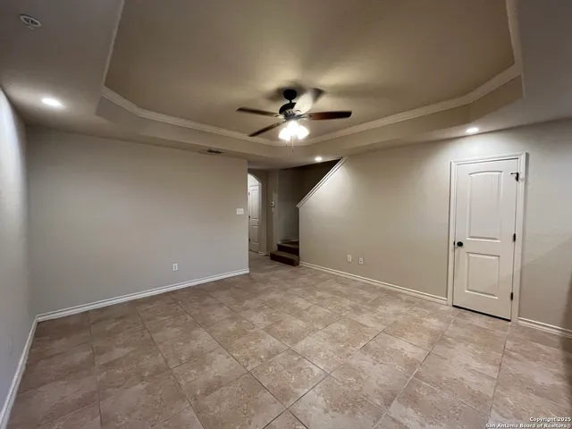 a view of an empty room and a ceiling fan
