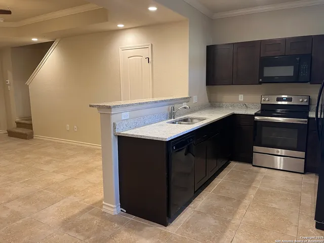 a kitchen with a sink and a stove top oven