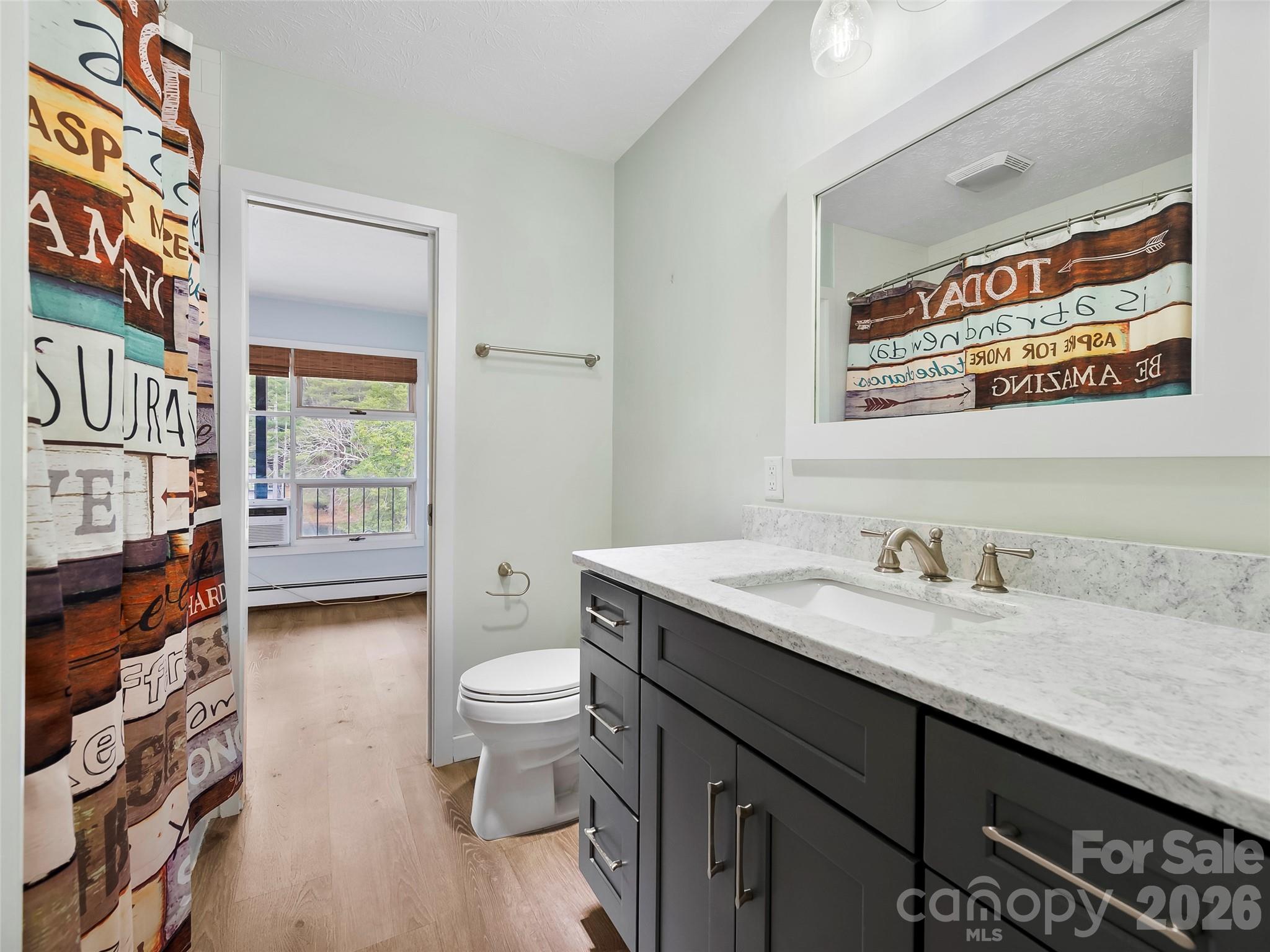 130 Old Mill Road, Unit 223 Flat Rock, NC 28731 - Photo 13 of 24 a bathroom with a granite countertop sink a toilet and a shower