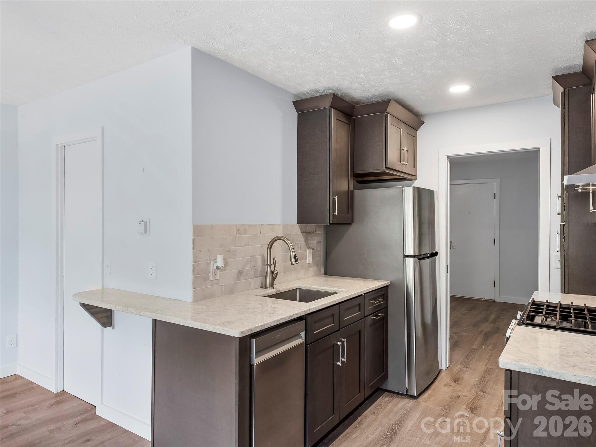 130 Old Mill Road, Unit 223 Flat Rock, NC 28731 - Photo 3 of 24 a kitchen with stainless steel appliances a refrigerator and a sink