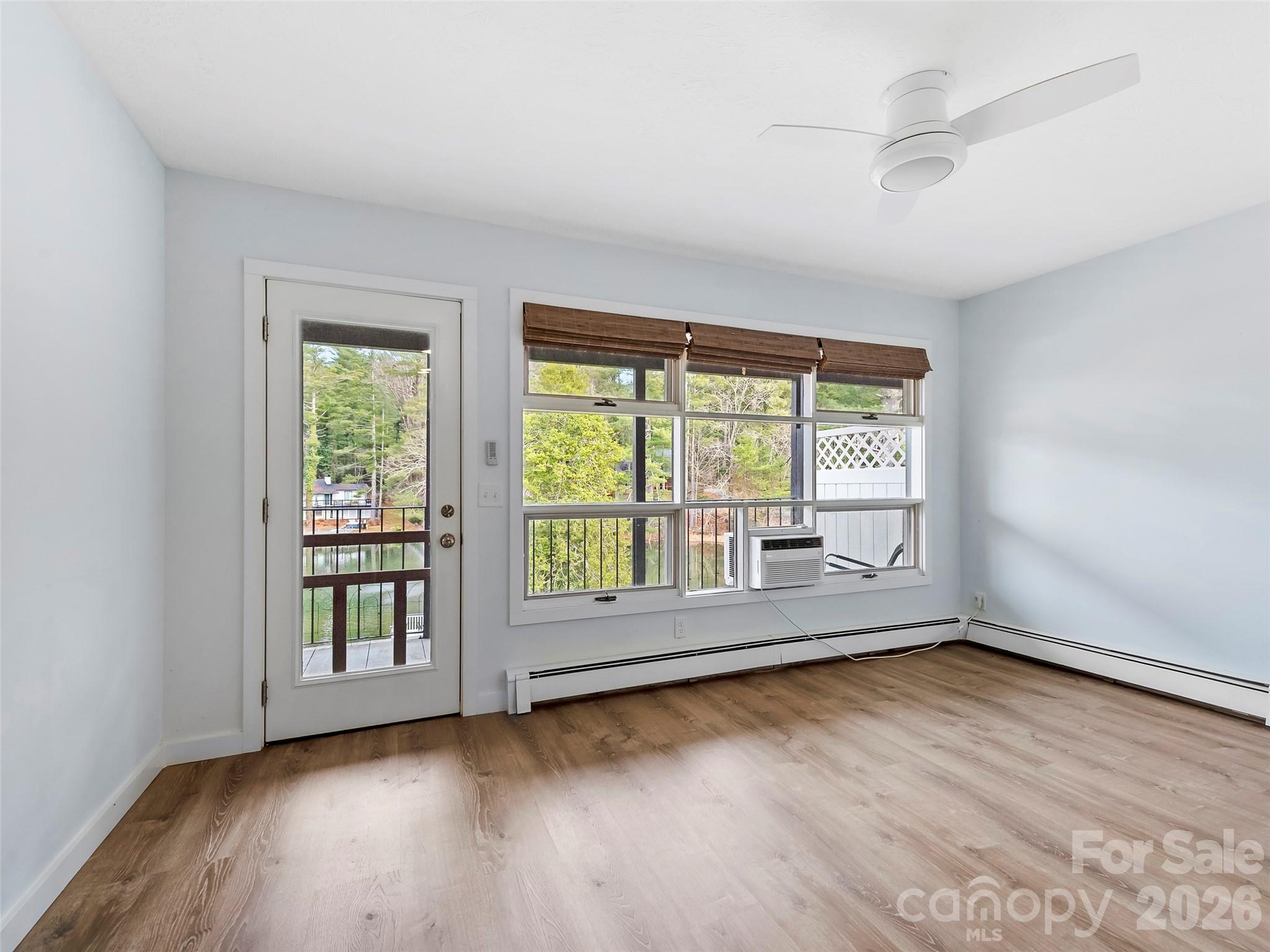 130 Old Mill Road, Unit 223 Flat Rock, NC 28731 - Photo 8 of 24 a view of an empty room with wooden floor and a window