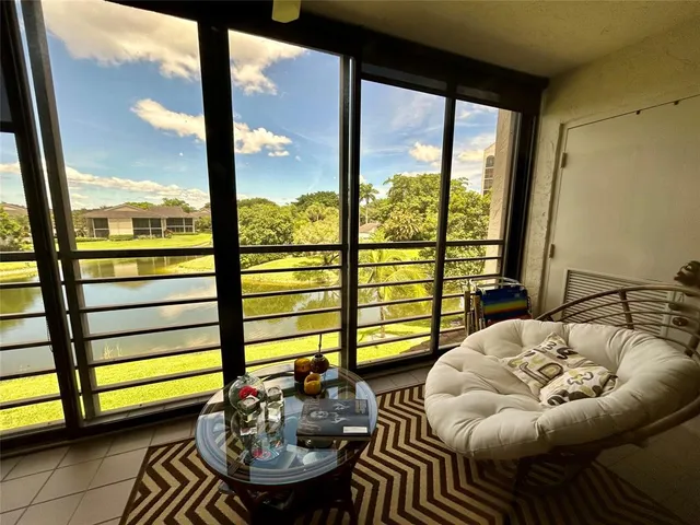 a living room with furniture and a floor to ceiling window