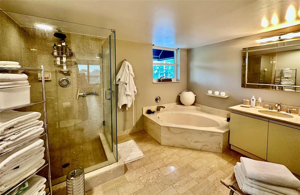 7582 Regency Lake Drive, Unit 301 Boca Raton, FL 33433 - Photo 11 of 20 a bathroom with a tub sink toilet and mirror