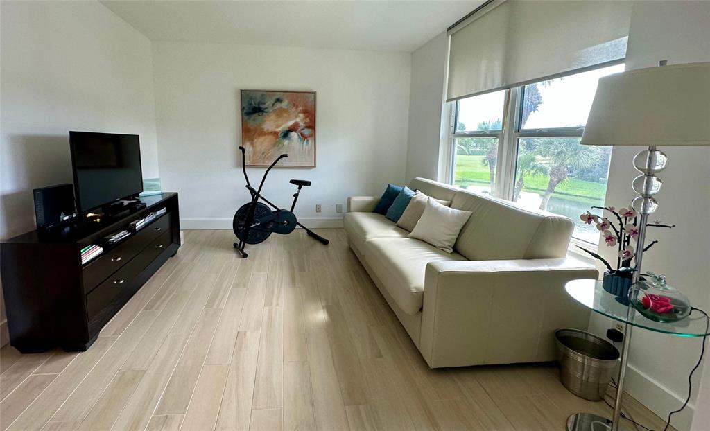 7582 Regency Lake Drive, Unit 301 Boca Raton, FL 33433 - Photo 15 of 20 a living room with furniture and a flat screen tv