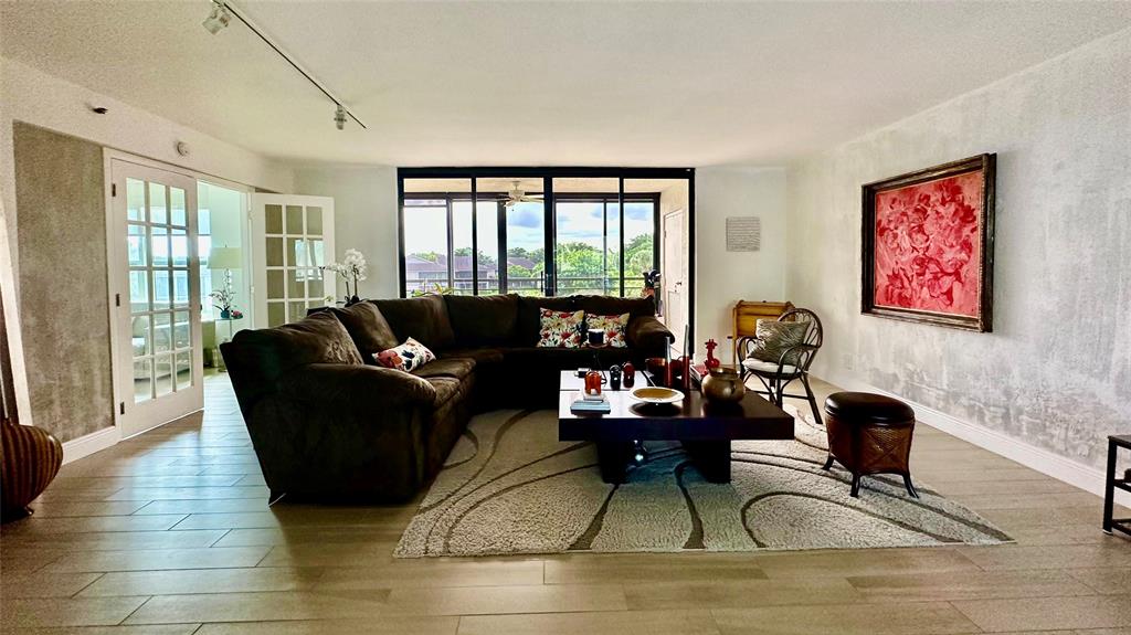 7582 Regency Lake Drive, Unit 301 Boca Raton, FL 33433 - Photo 2 of 20 a living room with furniture and a large window