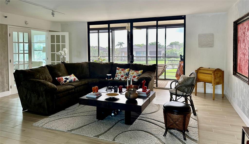 7582 Regency Lake Drive, Unit 301 Boca Raton, FL 33433 - Photo 3 of 20 a living room with furniture and floor to ceiling windows