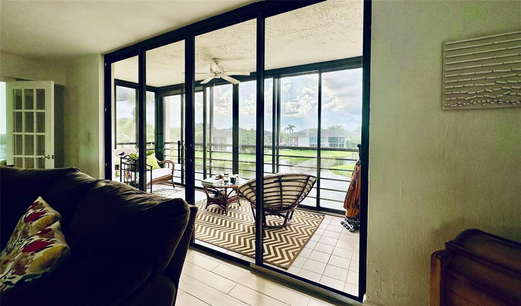 7582 Regency Lake Drive, Unit 301 Boca Raton, FL 33433 - Photo 4 of 20 a living room with furniture and a floor to ceiling window