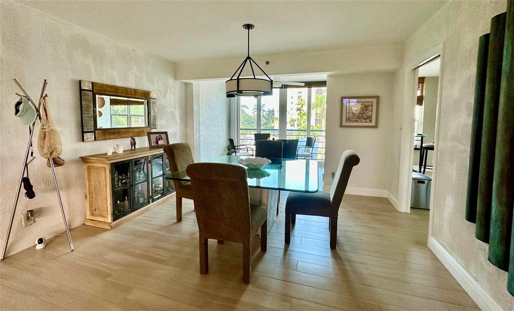 7582 Regency Lake Drive, Unit 301 Boca Raton, FL 33433 - Photo 5 of 20 a dining room with furniture window wooden floor and a chandelier