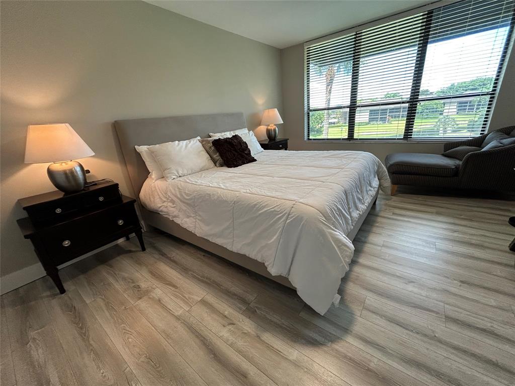 7582 Regency Lake Drive, Unit 301 Boca Raton, FL 33433 - Photo 7 of 20 a bedroom with a bed and a large window