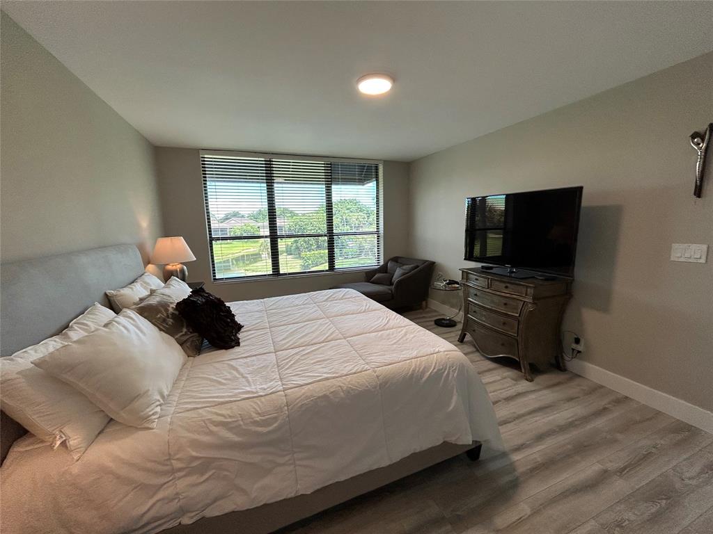 7582 Regency Lake Drive, Unit 301 Boca Raton, FL 33433 - Photo 9 of 20 a bedroom with a bed and a flat screen tv