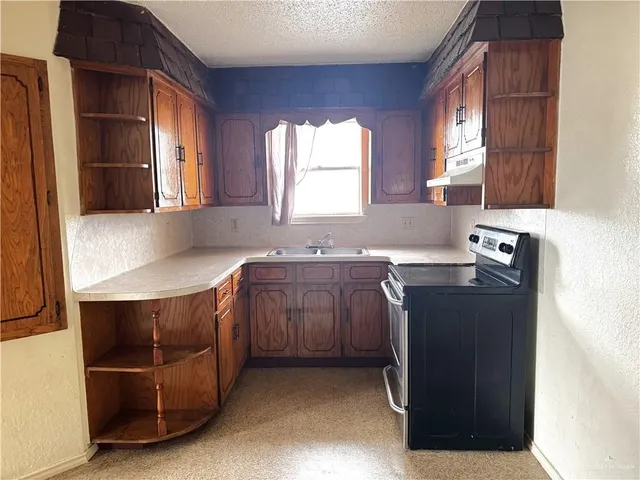 a kitchen with stainless steel appliances granite countertop a sink and a stove